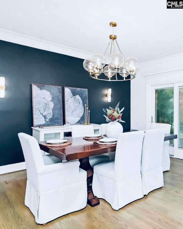 dining space with an inviting chandelier, ornamental molding, and light wood-type flooring