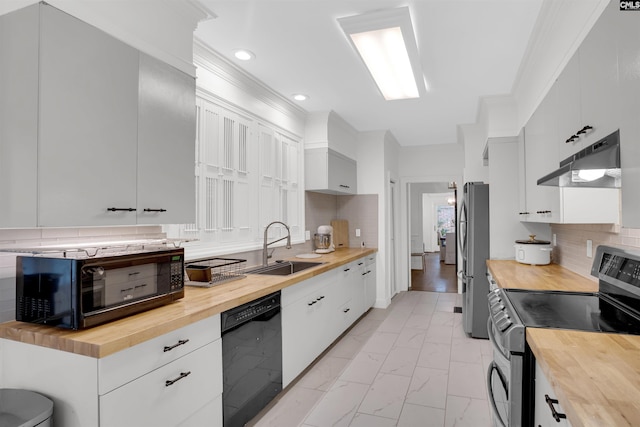 kitchen featuring tasteful backsplash, sink, white cabinets, wooden counters, and black appliances