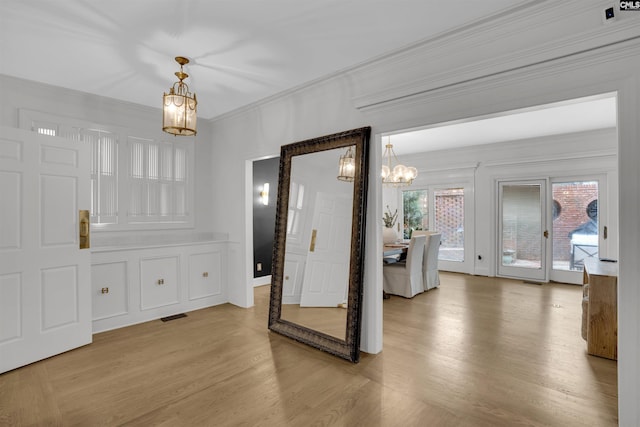 interior space featuring ornamental molding, hardwood / wood-style floors, and a chandelier