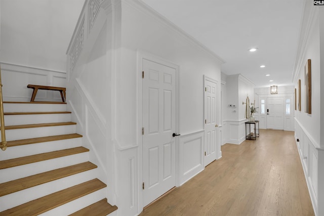 hall featuring crown molding and light hardwood / wood-style floors