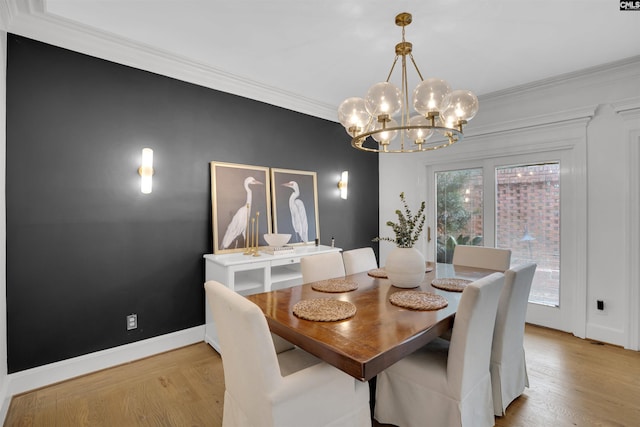 dining room featuring ornamental molding, a chandelier, and light hardwood / wood-style flooring