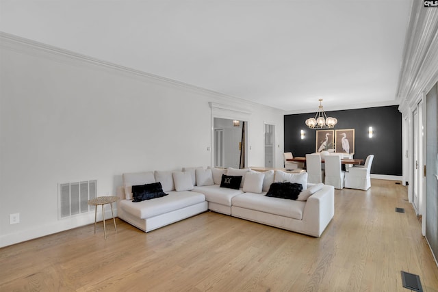 living room with crown molding, an inviting chandelier, and light hardwood / wood-style flooring