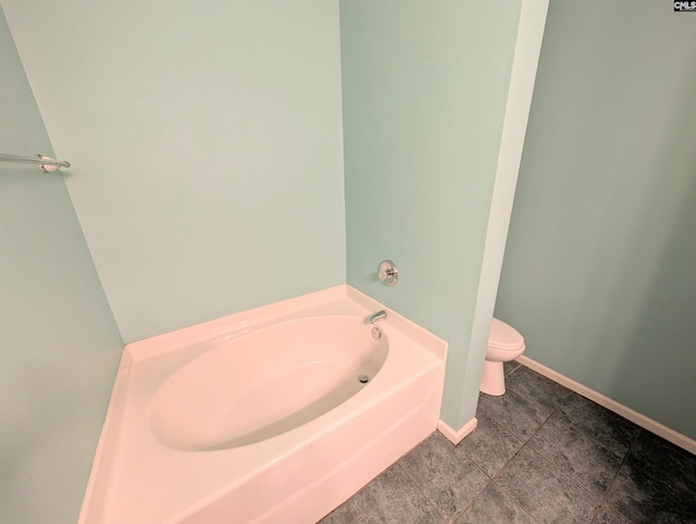 bathroom with a tub, tile patterned floors, and toilet