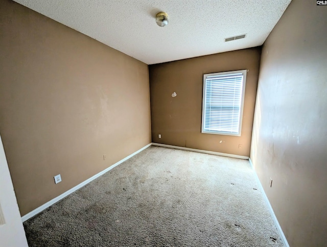 carpeted spare room featuring a textured ceiling