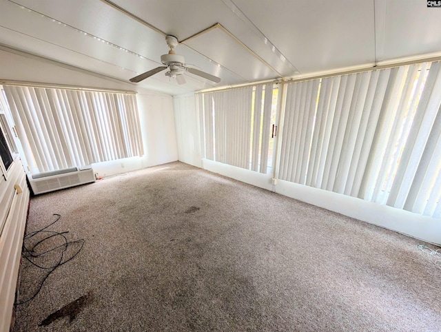 unfurnished sunroom featuring ceiling fan and a wall unit AC