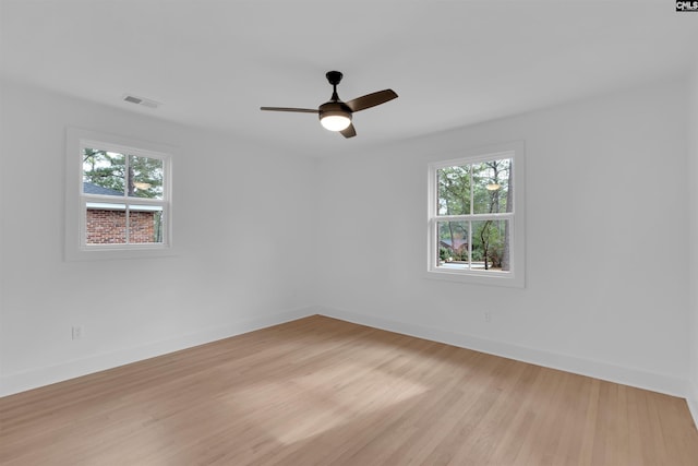 empty room with plenty of natural light, ceiling fan, and light hardwood / wood-style flooring