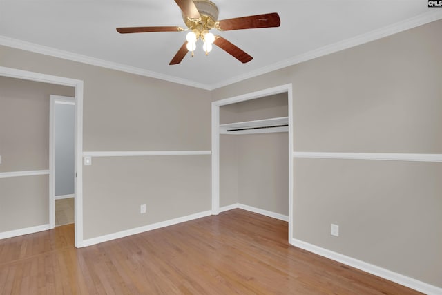 unfurnished bedroom featuring hardwood / wood-style flooring, ornamental molding, ceiling fan, and a closet