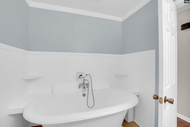 bathroom with crown molding and a bathing tub