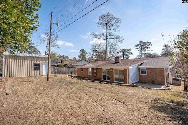 rear view of house featuring a shed, central AC unit, a lawn, and a patio