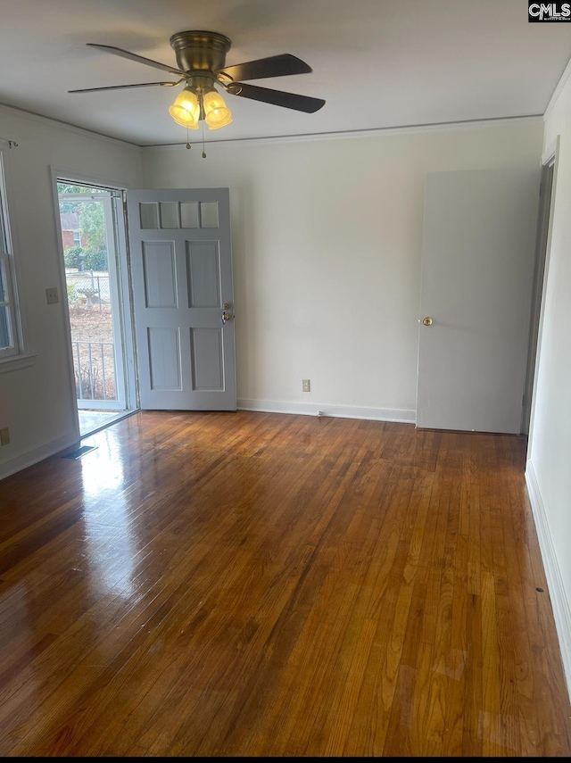 unfurnished room featuring dark wood-type flooring and ceiling fan