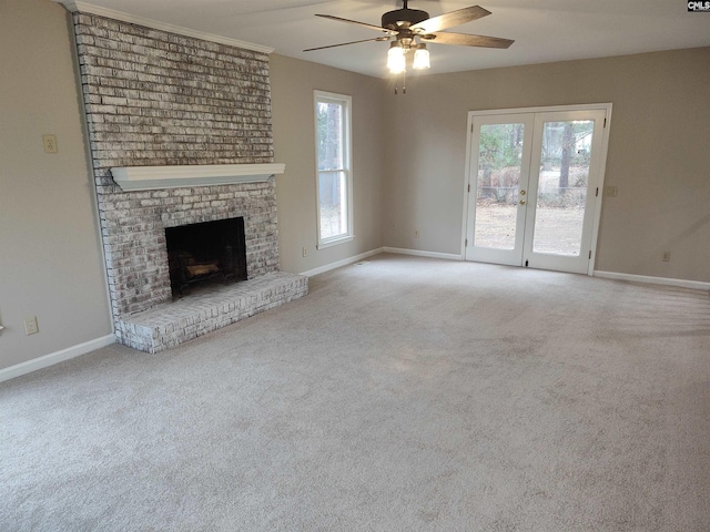 unfurnished living room featuring french doors, light colored carpet, plenty of natural light, and a brick fireplace