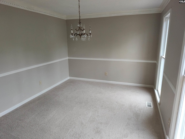 empty room featuring an inviting chandelier, ornamental molding, and carpet