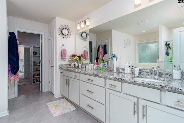 bathroom with tile patterned floors, vanity, and a shower with door