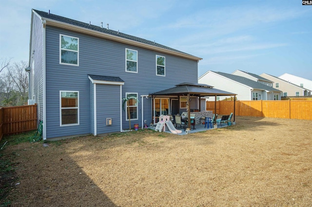 rear view of property with a gazebo, a yard, and a patio area