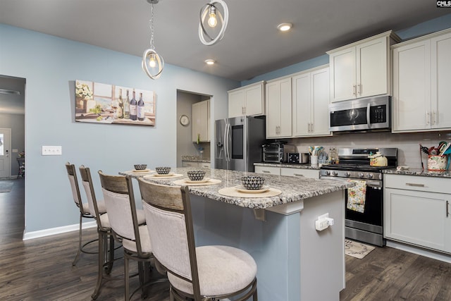 kitchen featuring light stone countertops, stainless steel appliances, and a center island