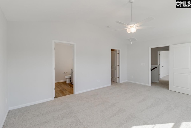 unfurnished bedroom featuring ceiling fan, lofted ceiling, ensuite bathroom, and light carpet