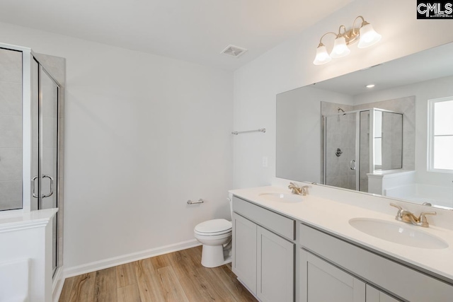 full bathroom with independent shower and bath, wood-type flooring, vanity, and toilet