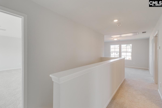 hallway featuring light colored carpet