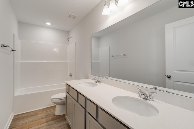 full bathroom with hardwood / wood-style flooring, vanity, toilet, and bathtub / shower combination