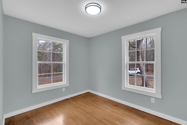 spare room featuring plenty of natural light and hardwood / wood-style floors