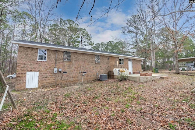 back of property with central AC and a patio area