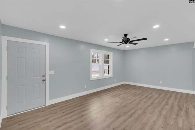 empty room with ceiling fan and light hardwood / wood-style flooring