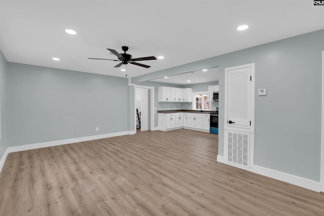 unfurnished living room with ceiling fan and light wood-type flooring