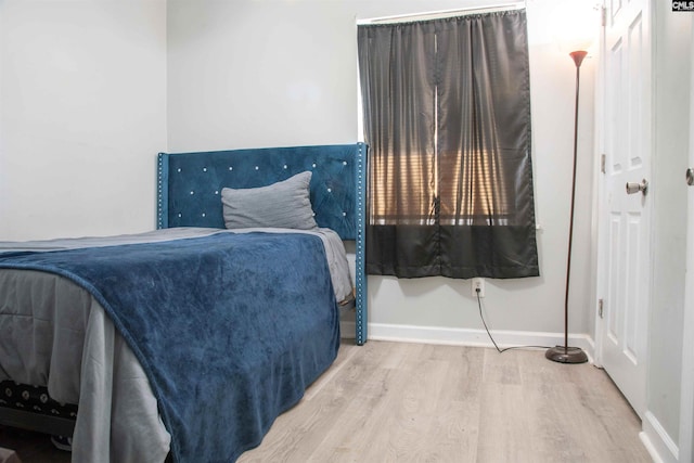 bedroom featuring baseboards and wood finished floors