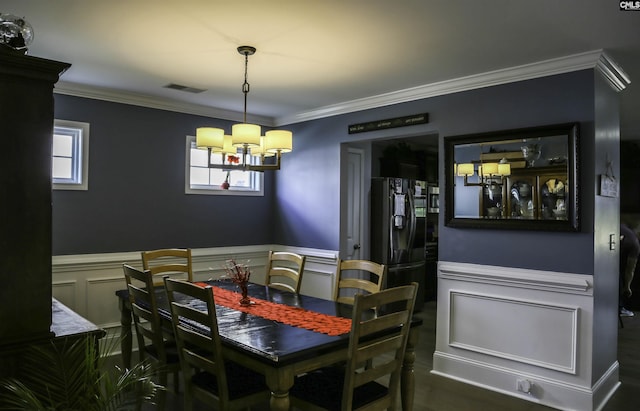 dining room with ornamental molding and an inviting chandelier