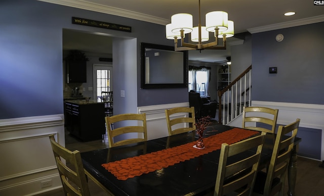 dining space featuring ornamental molding and ceiling fan with notable chandelier