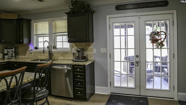 kitchen featuring dishwasher, sink, light stone counters, crown molding, and french doors