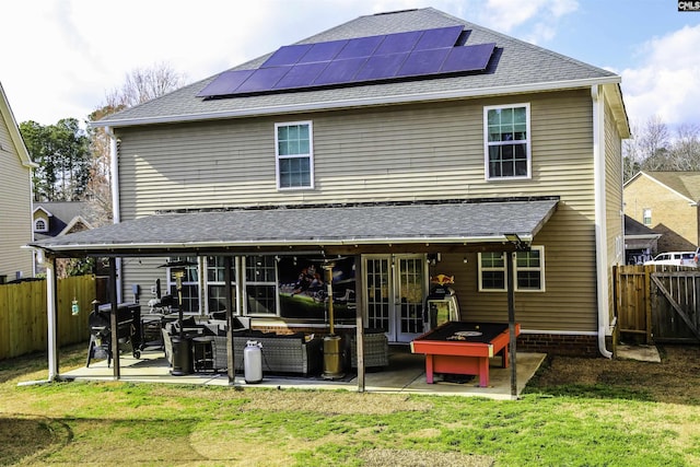 rear view of property with french doors, solar panels, a yard, an outdoor hangout area, and a patio