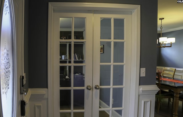 interior details with ornamental molding, an inviting chandelier, and french doors