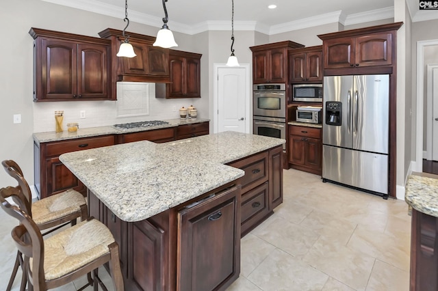 kitchen featuring pendant lighting, appliances with stainless steel finishes, backsplash, light stone counters, and a kitchen island