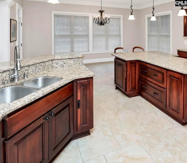 kitchen with pendant lighting, light stone countertops, and sink