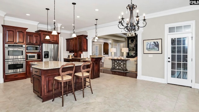 kitchen featuring a kitchen bar, crown molding, appliances with stainless steel finishes, pendant lighting, and a large island