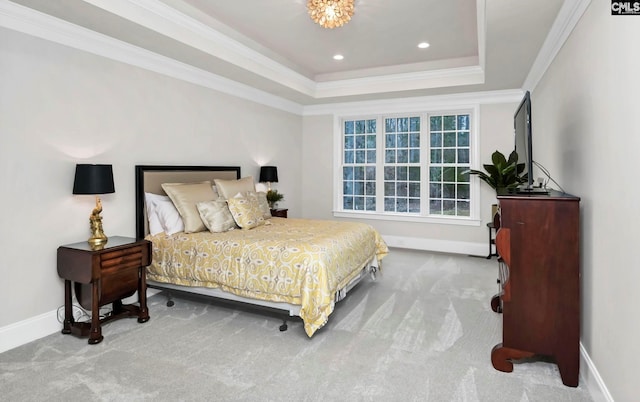 bedroom featuring crown molding, light colored carpet, and a tray ceiling