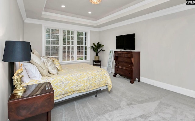 carpeted bedroom with ornamental molding and a tray ceiling