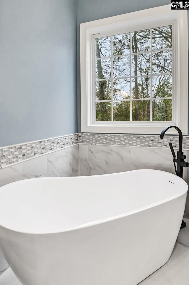 bathroom with a bath and tile walls