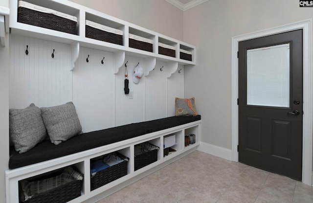 mudroom with crown molding and tile patterned floors