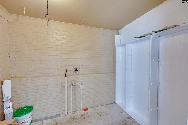 bathroom featuring brick wall and concrete floors