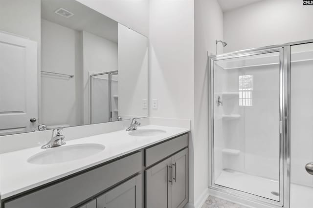 bathroom featuring a shower with door and vanity