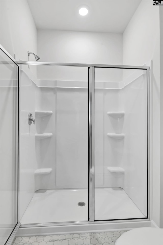 bathroom with an enclosed shower and toilet