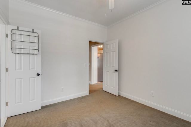 spare room with ceiling fan, ornamental molding, and light carpet