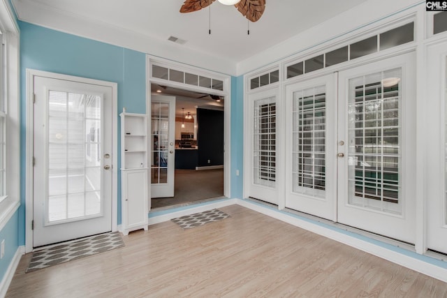 foyer featuring ornamental molding, french doors, ceiling fan, and light wood-type flooring