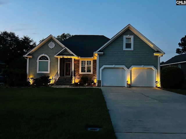 view of front of house featuring a garage and a yard