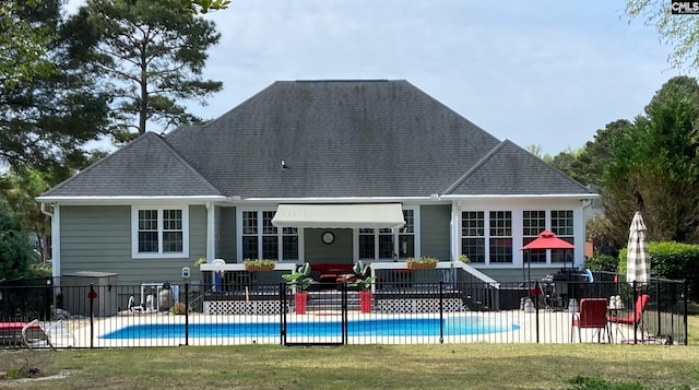 rear view of house featuring a community pool and a yard