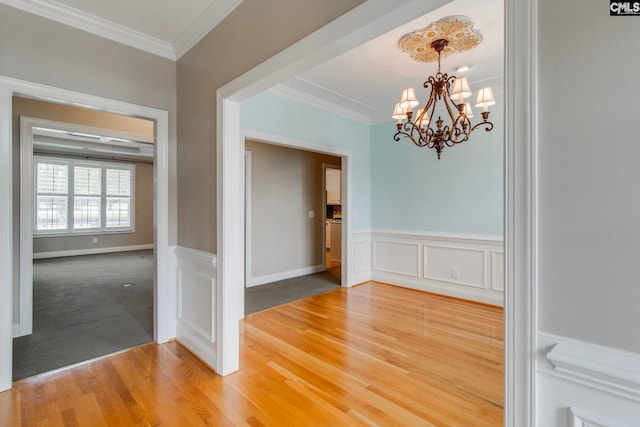 interior space featuring a notable chandelier, wood-type flooring, and ornamental molding