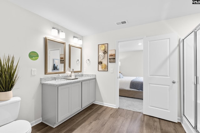 bathroom with vanity, an enclosed shower, wood-type flooring, and toilet