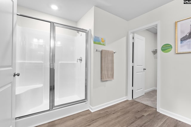 bathroom featuring a shower with door and hardwood / wood-style floors